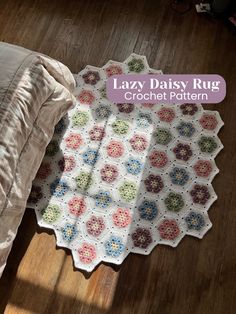 the lazy daisy rug crochet pattern is laying on the floor next to a bed