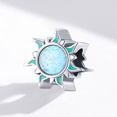 This is charm only, bracelet is sold separately. This cute Opal stone sun design charm for Pandora style bracelet is made of solid 925 sterling silver with platinum plating and multi color opal stones on both sides with enamel color decoration. Get ready to add a touch of elegance and luxury to your bracelet with this stunning Opal stone sun charm. Made with high-quality sterling silver and adorned with beautiful multi-colored opal stones on both sides, this charm is a must-have for any fashion-forward jewelry lover. The sun design adds a playful and whimsical touch, while the enamel color decoration adds a pop of color and personality. Elevate your style with this unique and eye-catching charm today! Materials: 925 sterling silver, synthetic opalFinish: platinum plateDimensions: 0.45 x 0. Celestial Silver Jewelry With Charms, Sterling Silver Gemstone Charms, Celestial Style Silver Opal Jewelry, Silver Sun Design Jewelry As A Gift, Blue Sterling Silver Jewelry With Sun And Moon Design, White Gold Sterling Silver Sun And Moon Jewelry, Celestial Silver Jewelry With Cabochon, Celestial Silver Opal Jewelry, Silver Celestial Jewelry With Cabochon