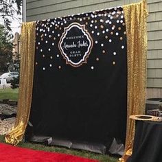 a black and gold wedding backdrop with confetti on the side for an outdoor ceremony