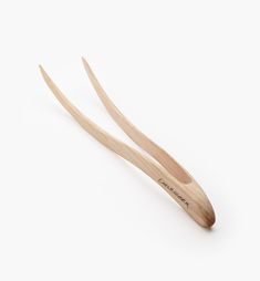 two wooden spoons sitting on top of each other in front of a white background