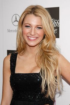 a beautiful blonde woman in a black dress posing for the camera with her hand on her hip