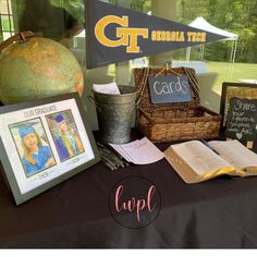 a table topped with books and pictures next to a sign