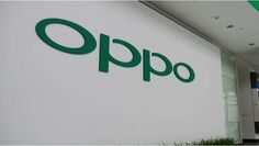 the oppo sign is on the side of an office building in front of a green plant