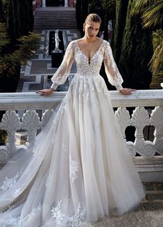 a woman in a wedding dress standing on a balcony