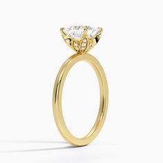 a yellow gold ring with an oval cut diamond