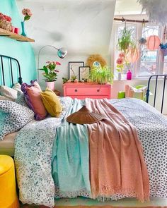 a bed room with a neatly made bed and lots of plants on the shelves above it