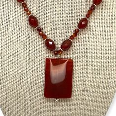 This is a beautiful, red carnelian beaded pendant choker. Oval and round carnelian beads are separated by sterling caviar-style beads on the estate necklace. The pendant is a rectangular red carnelian. This semi-precious gemstone symbolizes health, luck, and royalty. It is a variety of the silica mineral chalcedony colored by impurities of iron oxide. The necklace fastens with a silver toggle clasp. Brand: Unknown Markings: Unmarked metal; this item has been tested to confirm metal content. Mate Multi Gemstone Ring, Red Carnelian, Pendant Choker, Carnelian Beads, Beaded Pendant Necklace, Beaded Hoop Earrings, Beaded Hoops, Hand Jewelry, Iron Oxide