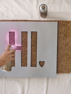 someone is painting the letters on a door with pink light up paint and glitter glue