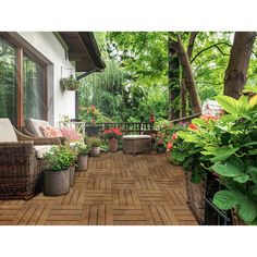 an outdoor deck with wicker furniture and potted plants