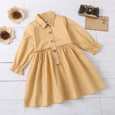 Girls Button Long Sleeve Solid Lapel Pleated Dress Bulk Kids Clothes - PrettyKid Cute Button Dresses For Fall, Cute Buttoned Fall Dresses, Cute Fall Dresses With Buttons, Yellow Long Sleeve Dress With Buttons, Cotton School Dresses With Buttons, Spring School Dresses With Buttons, Yellow Long Sleeve Dress For Playtime, Cute Button-up Dress With Buttons, Cute Doll Collar Dress With Buttons