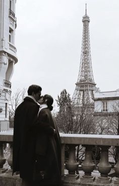 a couple kissing in front of the eiffel tower