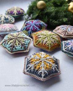 crocheted snowflakes are arranged on a table next to christmas decorations