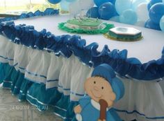 a table with blue and white decorations on it, including balloons in the shape of a baby's head