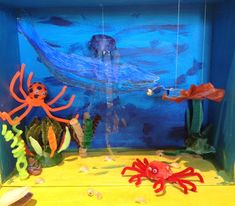 an aquarium with plastic sea animals and other marine creatures on the bottom part of it