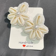 Beautiful Cowry shell stud earrings . Perfect to wear on vacations or beach.  Best thing is that it can be worn for long hours as it is lightweight. 100% Handmade Closure- pushback Back of the earring is white leather. Each piece is handmade with love.  Free shipping to Canada and USA. It will be shipped via regular non trackable Canada post parcel within 2 days after placing the order. Estimate shipping times for Canada is 4-6 days. USA- 1-2 weeks. Thankyou for checking out my shop! If you have Unique Earring Designs, White Bead Earrings, Shells Earrings, Handmade Earings, Alphabet Keychain, Cowrie Shell Earrings, Cowrie Shell Jewelry, Embroidered Earrings, Business Graphics