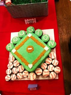 a baseball themed cake on a table with cupcakes in the shape of a base