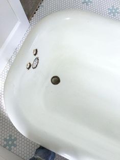 a white sink sitting on top of a tiled floor