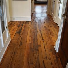 an open door leading into a room with wood flooring and white trim on the walls