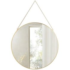 a round mirror hanging on a chain next to a window