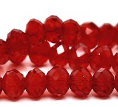 red glass beads are lined up on a white surface