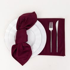 a white plate topped with a fork and knife next to a napkin