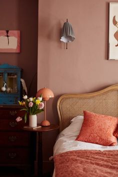 a bedroom with pink walls and wooden furniture