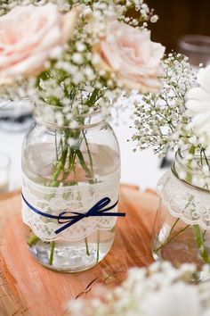 two vases filled with flowers and baby's breath are sitting on a table