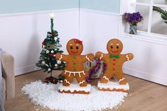 two gingerbread men are standing in front of a christmas tree and presents on the floor