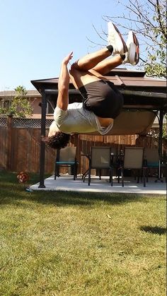 a man is doing a handstand in the yard