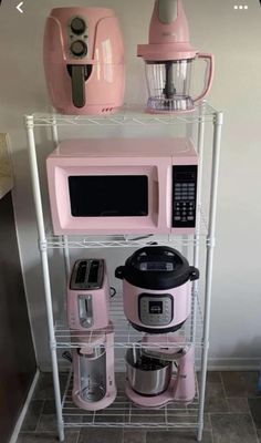 a pink kitchen appliance sitting on top of a shelf next to other appliances