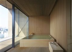 an empty bathtub in the middle of a room with wooden slats on the walls