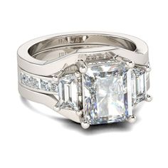 an engagement ring with three princess cut diamonds on the side and two baguetts set in