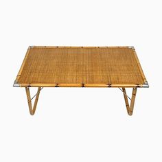 a table made out of bamboo with metal legs and a rectangular top, on a white background