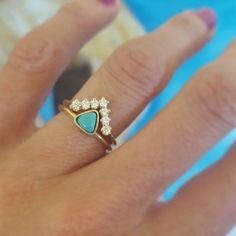 a close up of a person's hand wearing a gold ring with blue and white stones