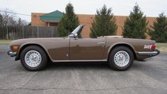 a brown sports car parked in a parking lot