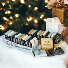 a bunch of soaps sitting on top of a white blanket next to a christmas tree