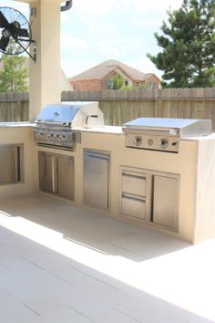 an outdoor kitchen with stainless steel appliances and grill