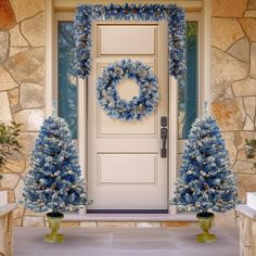 a front door decorated with blue christmas wreaths