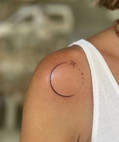 a woman's arm with a small tattoo on the left side of her shoulder