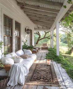 the porch is covered with white furniture and pillows, along with an area rug on the floor