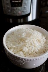 rice in a white bowl next to an instant pot