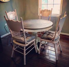 a wooden table with chairs around it in front of a clock on the wall and window