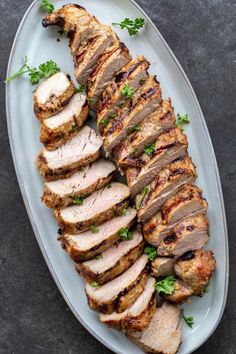 sliced pork on a plate with parsley garnish