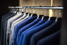 several shirts hanging on a rail in a closet