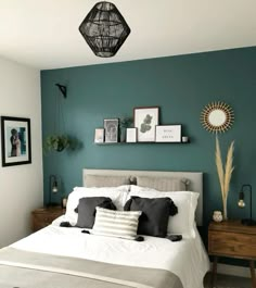 a bedroom with teal walls and white bedding