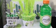 a table topped with green drinks and candy