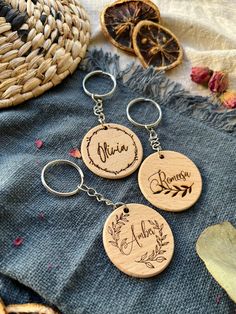 three personalized wooden keychains on top of a blue blanket with dried oranges