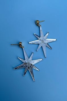 Silver earrings with a unique star shape and a lightweight feel. They are fashionable and are fun for the holidays. From the vendor; We devote great care to crafting every piece, ensuring a high level of attention to detail. Our use of nickel-free metal ensures that each piece is hypoallergenic. While our earrings are designed to be durable, we suggest handling them with care, as they are works of wearable art. Nickel free. Nickel-free Metal Star Earrings, Nickel-free Star-shaped Metal Earrings, Nickel-free Star Shaped Metal Earrings, Trendy Silver Star Earrings, Star-shaped Metal Earrings For Party, Silver Star Charm Earrings For Party, Pierced Star-shaped Metal Earrings, Pierced Metal Star Earrings, Silver Star Embellished Earrings For Party