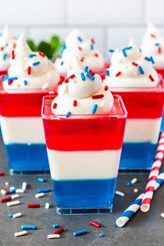 red, white and blue desserts with sprinkles in small cups on a table