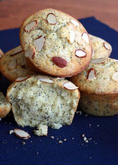 a pile of muffins sitting on top of a blue cloth covered in nuts